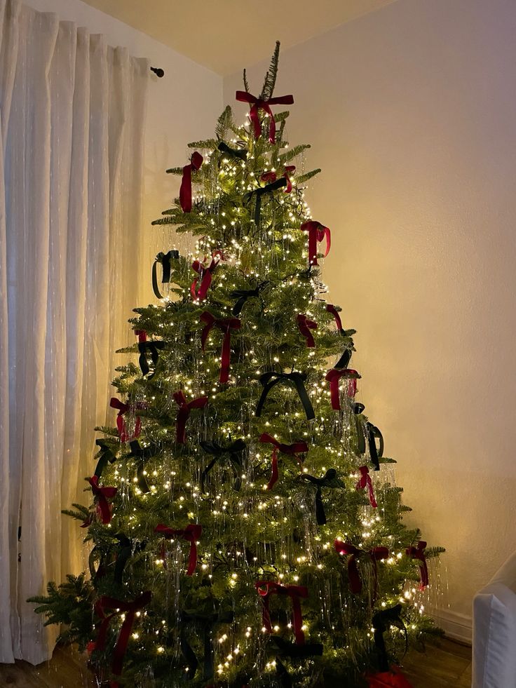 Red and green bow decor on christmas tree…